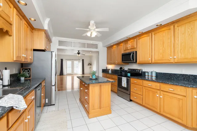 a kitchen with stainless steel appliances granite countertop a stove a sink and a microwave