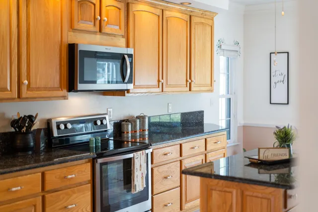 a kitchen with stainless steel appliances granite countertop a stove and a microwave