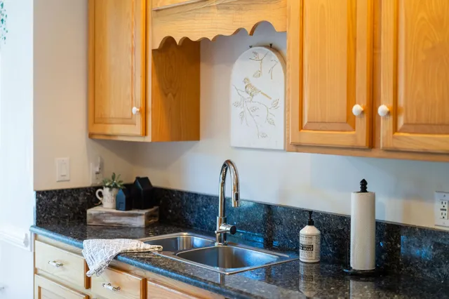 a bathroom with a granite countertop sink mirror vanity and toilet