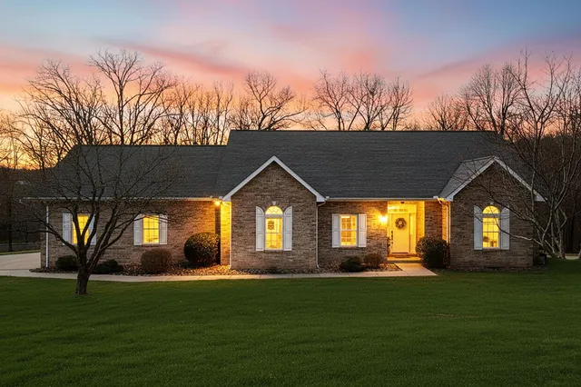a front view of a house with a garden and trees