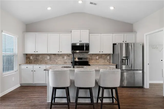 a kitchen with a table chairs refrigerator and microwave