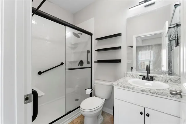 a bathroom with a granite countertop sink toilet and shower