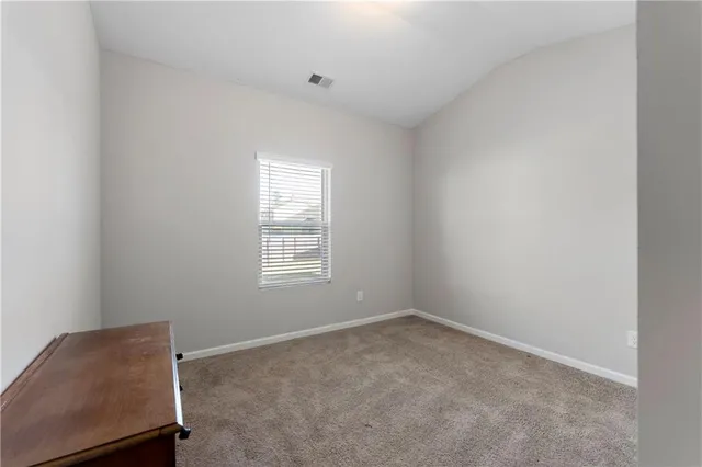 an empty room with a chair and window