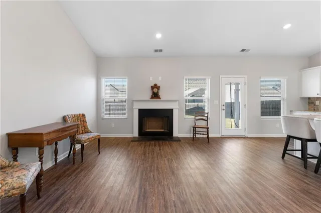 a view of a livingroom with furniture a fireplace and wooden floor