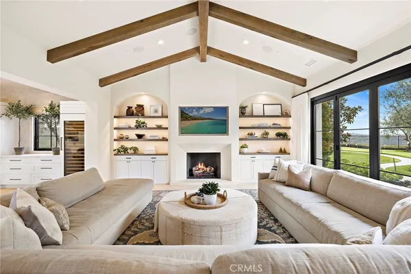 a living room with furniture a fireplace and a large window