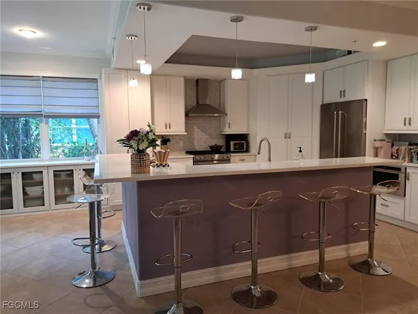 a kitchen with a table chairs refrigerator and wooden cabinets