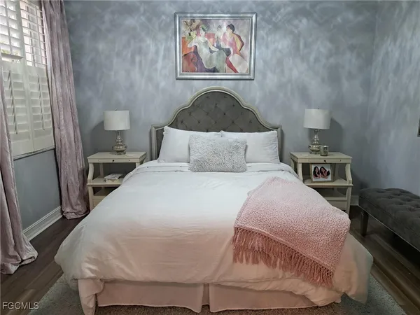 a bedroom with a bed and a painting on the wall