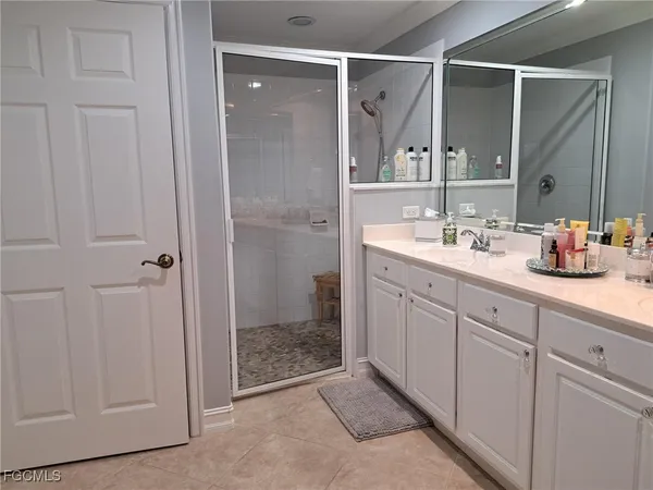 a spacious bathroom with a shower sink and mirror