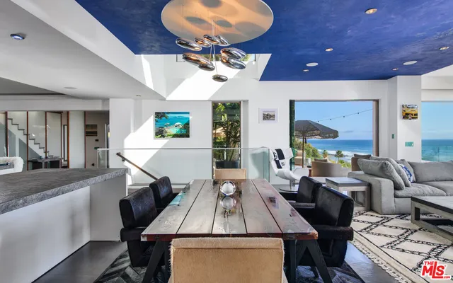 a living room with furniture a chandelier and a flat screen tv