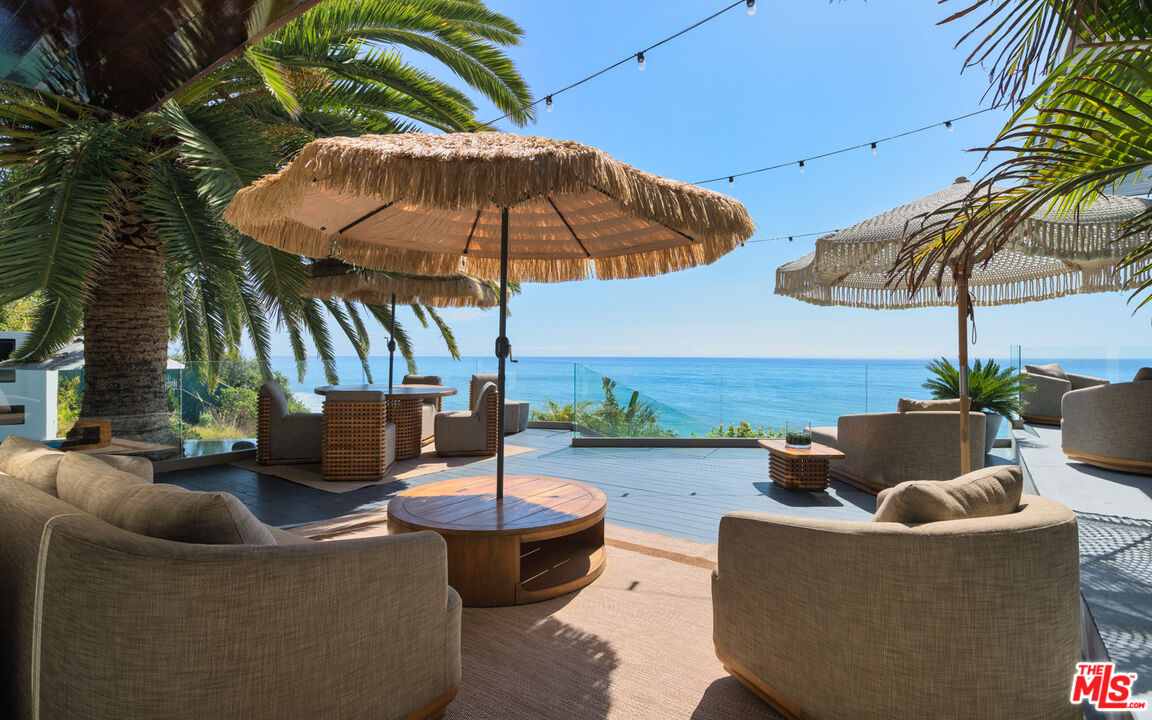 33406 Pacific Coast Highway Malibu, CA 90265 - Photo 28 of 51 a patio with patio a table and chairs under an umbrella