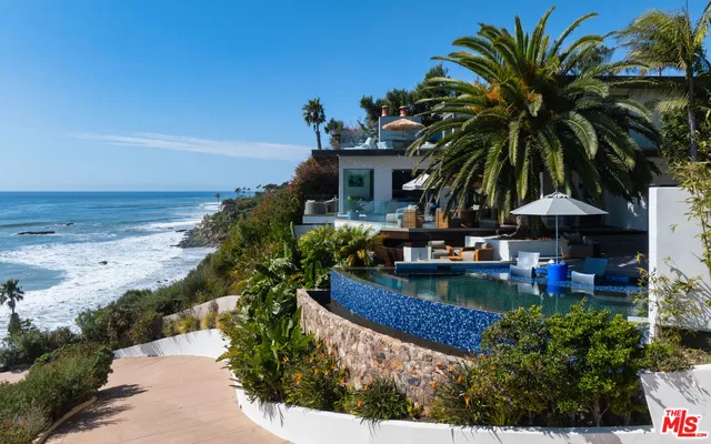a view of a house with a yard and potted plants