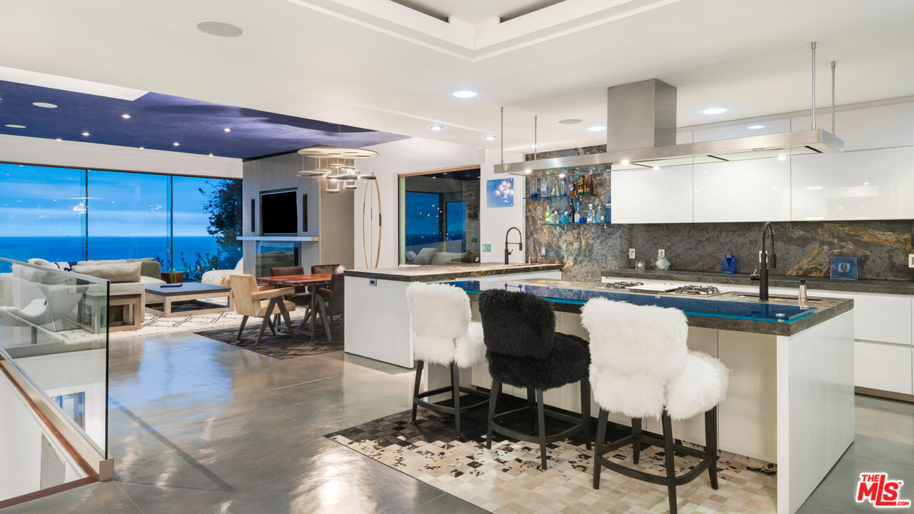 33406 Pacific Coast Highway Malibu, CA 90265 - Photo 39 of 51 a kitchen with stainless steel appliances granite countertop a sink a stove a refrigerator cabinets and chairs