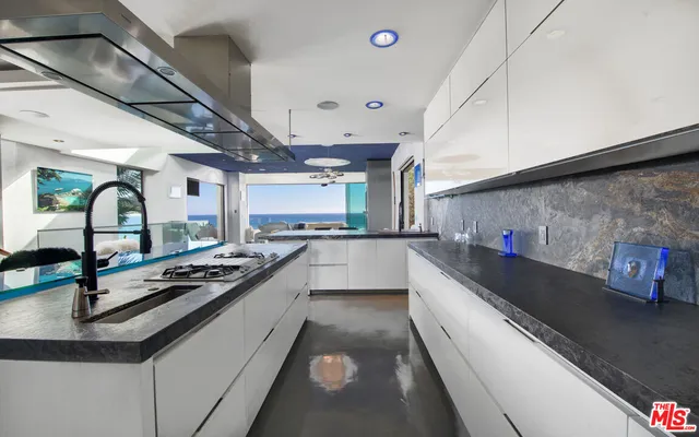 a kitchen with stainless steel appliances granite countertop a sink and stove