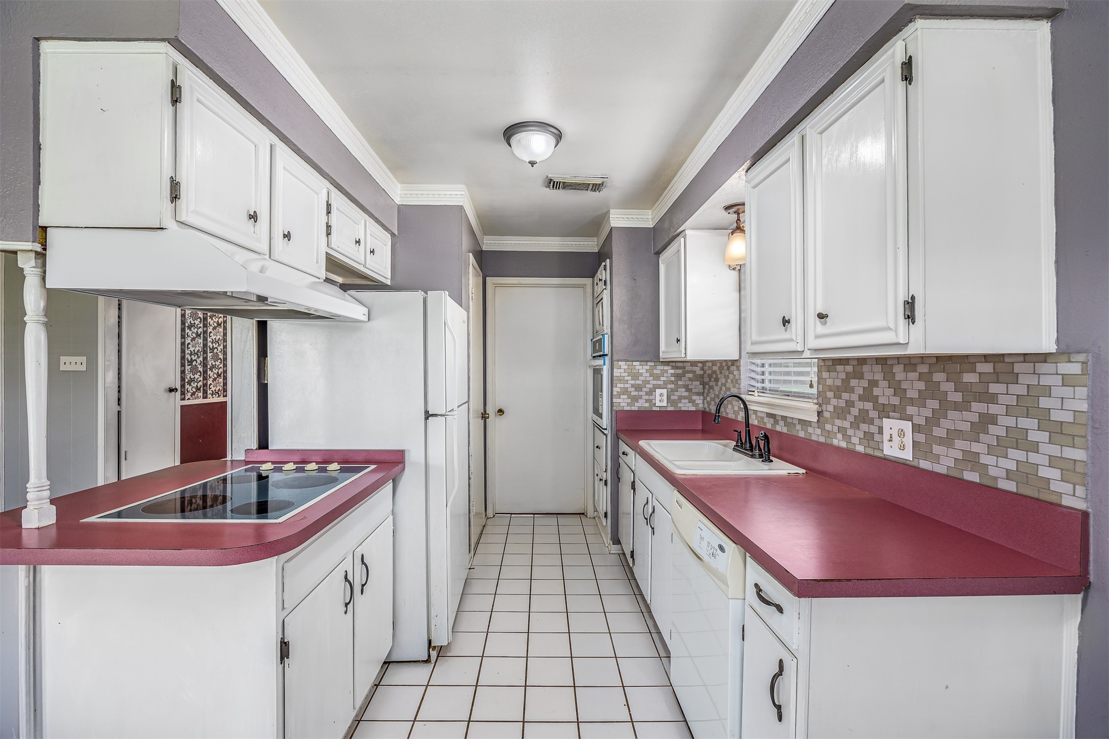 206 Kelly Lane Baytown, TX 77521 - Photo 15 of 38 The galley style kitchen is ideal for food prep. The refrigerator is included with the home, making move-in, that much easier.