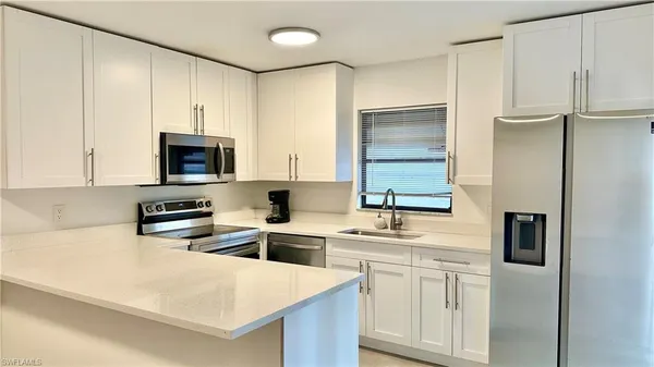 a kitchen with appliances a sink and cabinets