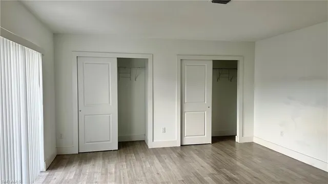 an empty room with wooden floor and closet