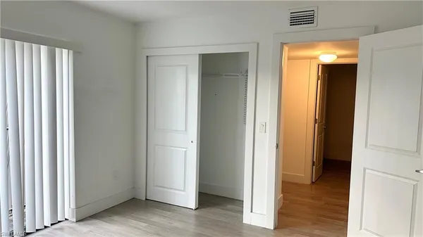 a white toilet sitting next to a white wall