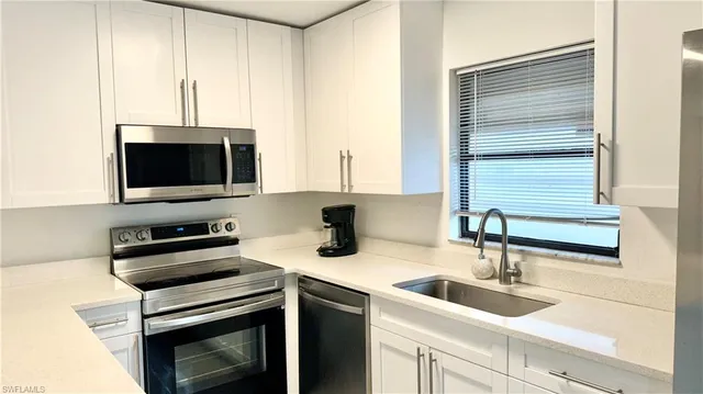 a kitchen with a sink and a stove top oven with wooden floor