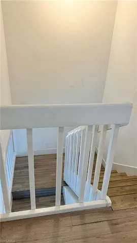 a view of staircase with white walls and railing