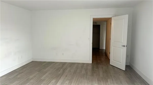 an empty room with wooden floor and closet