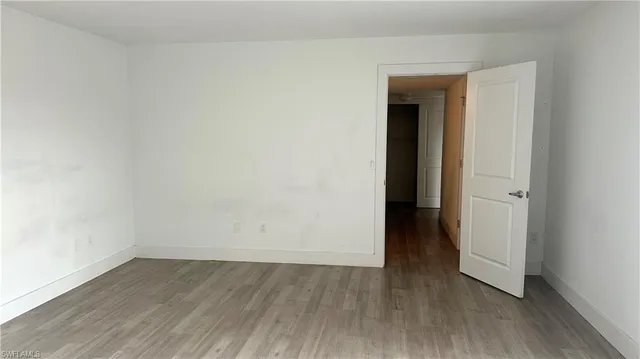 an empty room with wooden floor and closet