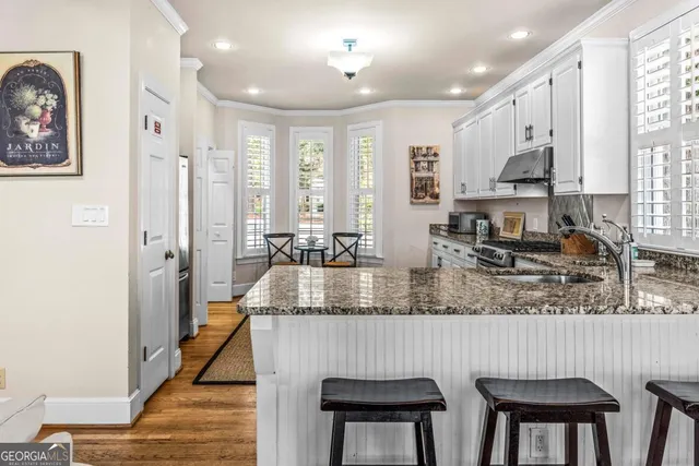 a kitchen with stainless steel appliances granite countertop a sink refrigerator and cabinets
