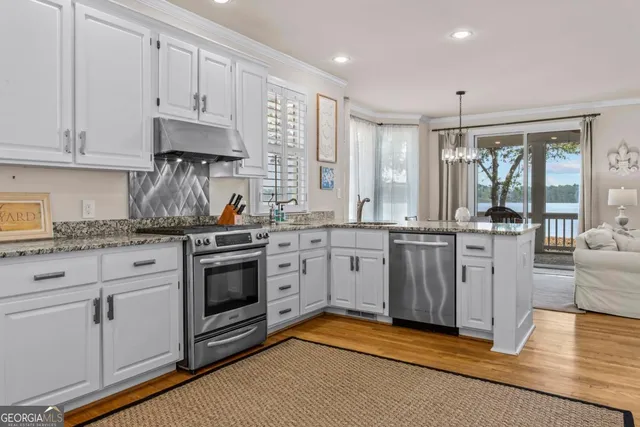 a kitchen with white cabinets a sink dishwasher and a stove with wooden floor