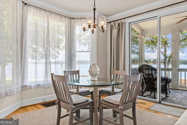 a dining room with furniture a chandelier and wooden floor