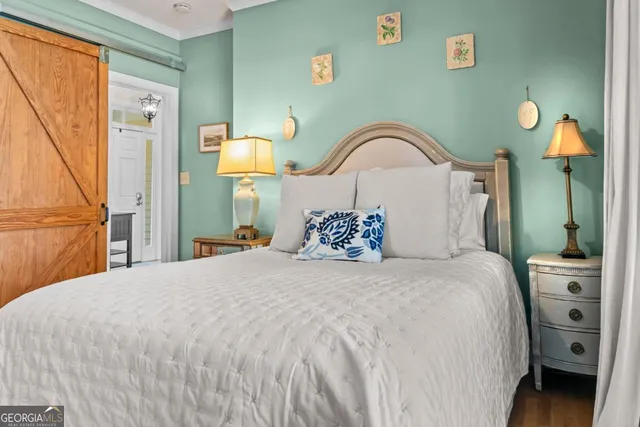 a bedroom with a bed and a painting on the wall