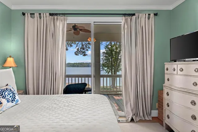 a bedroom with a bed and large windows