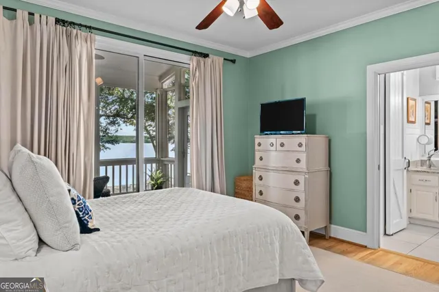 a bedroom with a bed and a flat tv screen on dresser