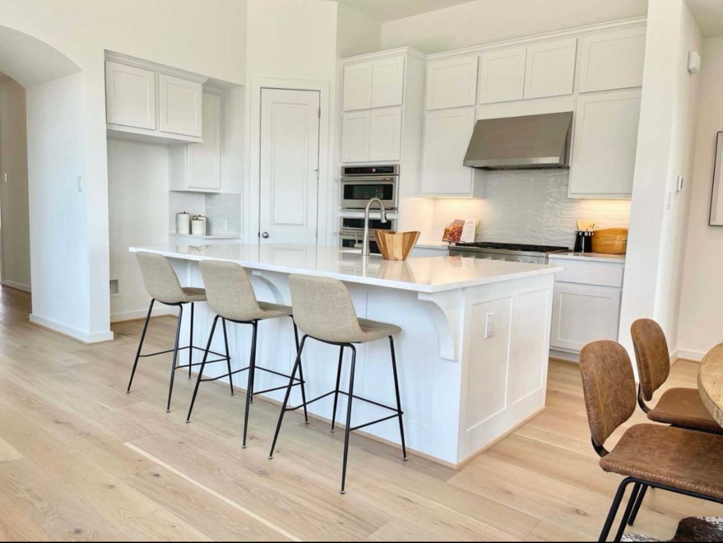 1116 Addison Lane Georgetown, TX 78628 - Photo 3 of 17 a kitchen with stainless steel appliances granite countertop a stove top oven a sink dishwasher and white cabinets with wooden floor