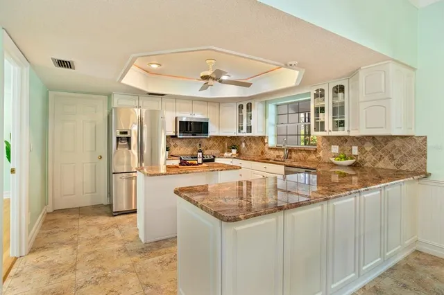 a kitchen with white cabinets and stainless steel appliances