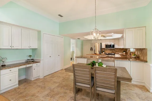 a living room with furniture kitchen area and a large window