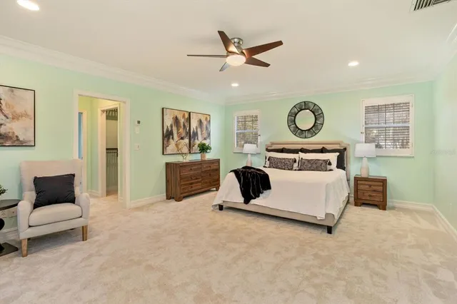 a bedroom with a bed and large windows