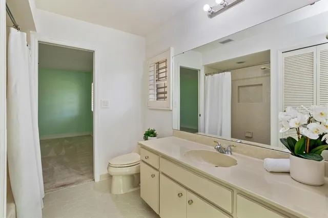 a view of a big room with windows and chandelier fan