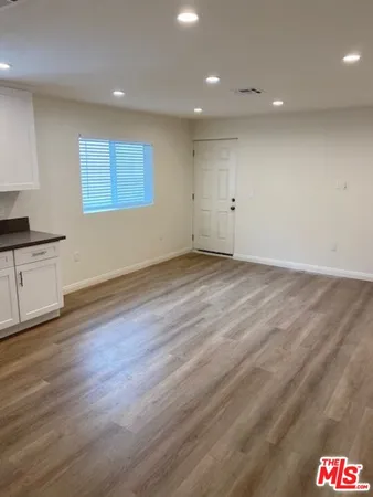 an empty room with wooden floor and white walls