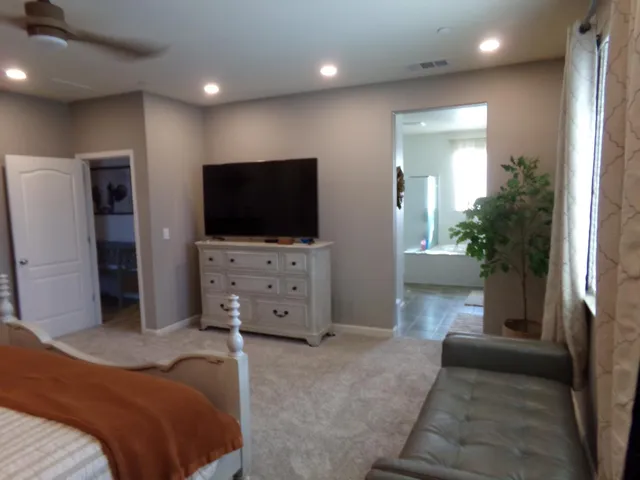 a bedroom with furniture and a flat screen tv