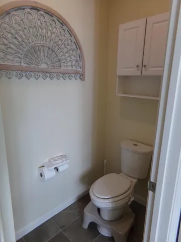 a white toilet sitting next to a shower