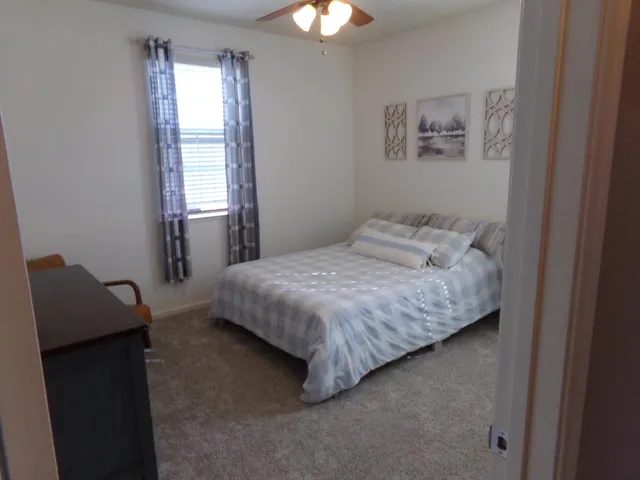 a living room with furniture a flat screen tv and a chandelier