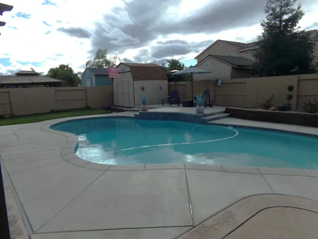 a backyard of a house with barbeque oven and outdoor seating