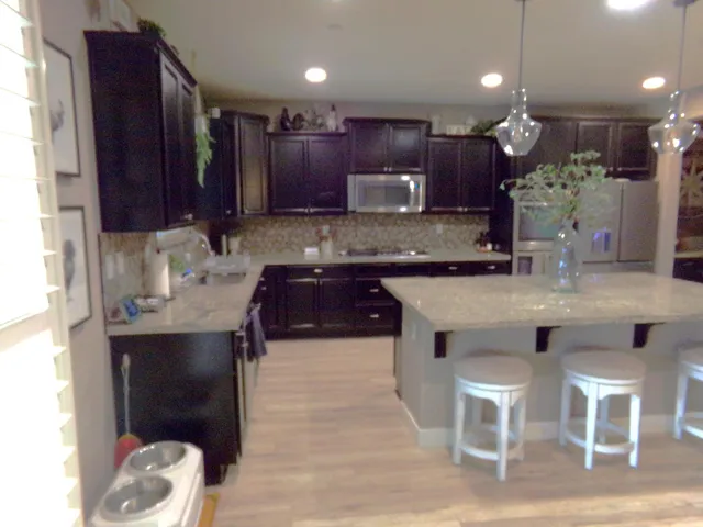 a kitchen with kitchen island granite countertop wooden cabinets and a refrigerator