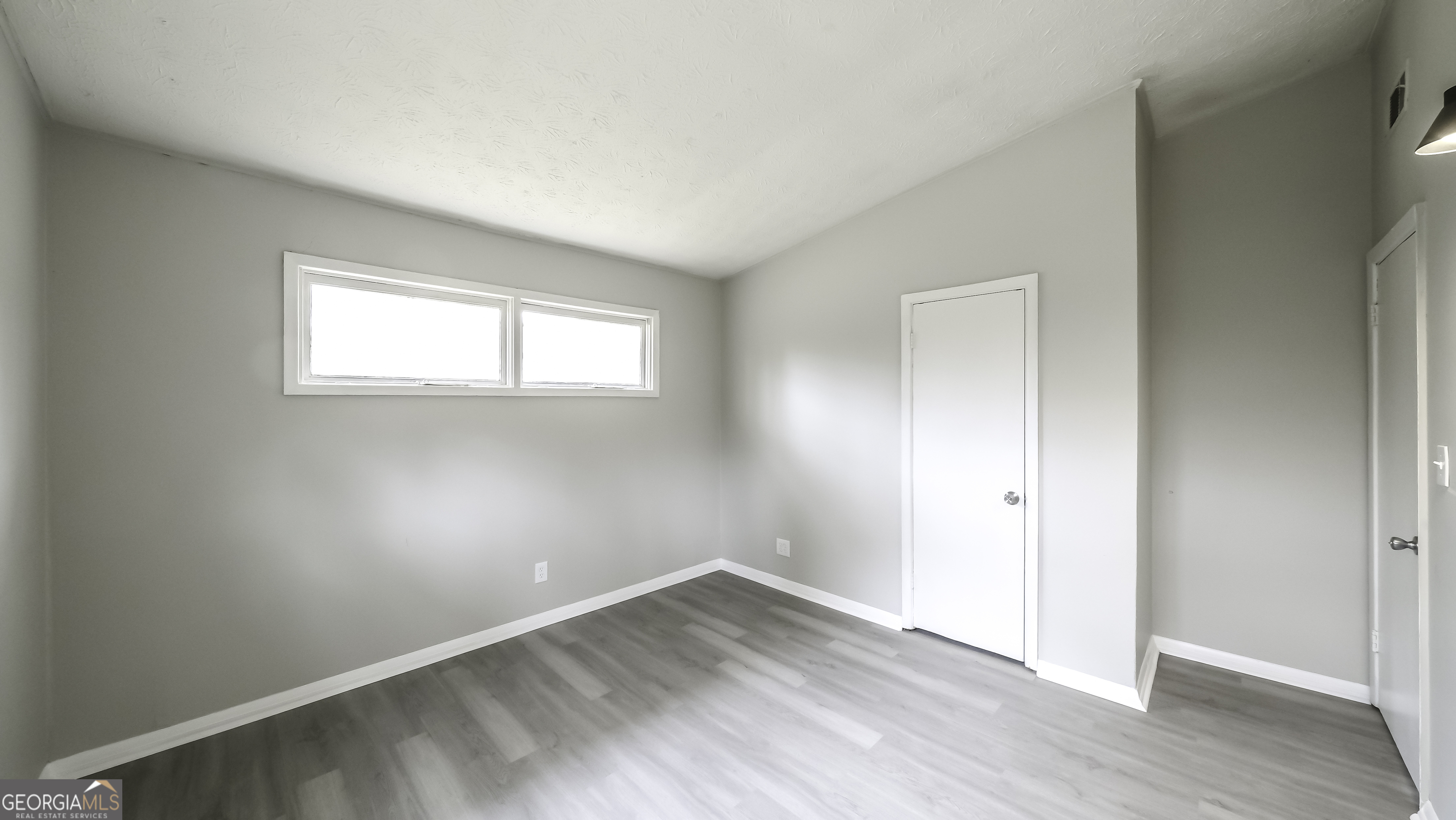 208 Richards Street Carrollton, GA 30117 - Photo 11 of 42 an empty room with wooden floor and windows