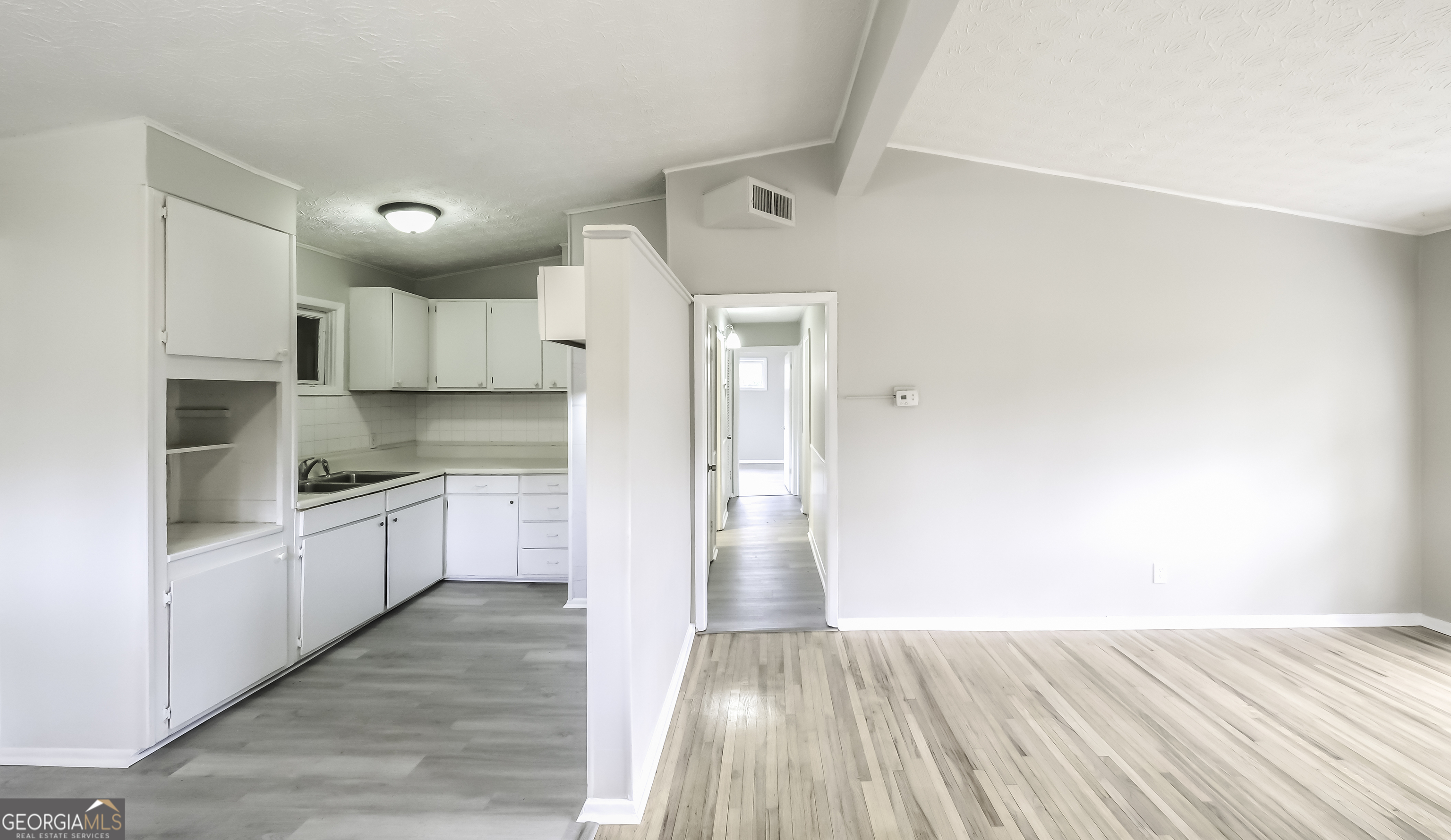 208 Richards Street Carrollton, GA 30117 - Photo 22 of 42 a large kitchen with cabinets wooden floor and stainless steel appliances