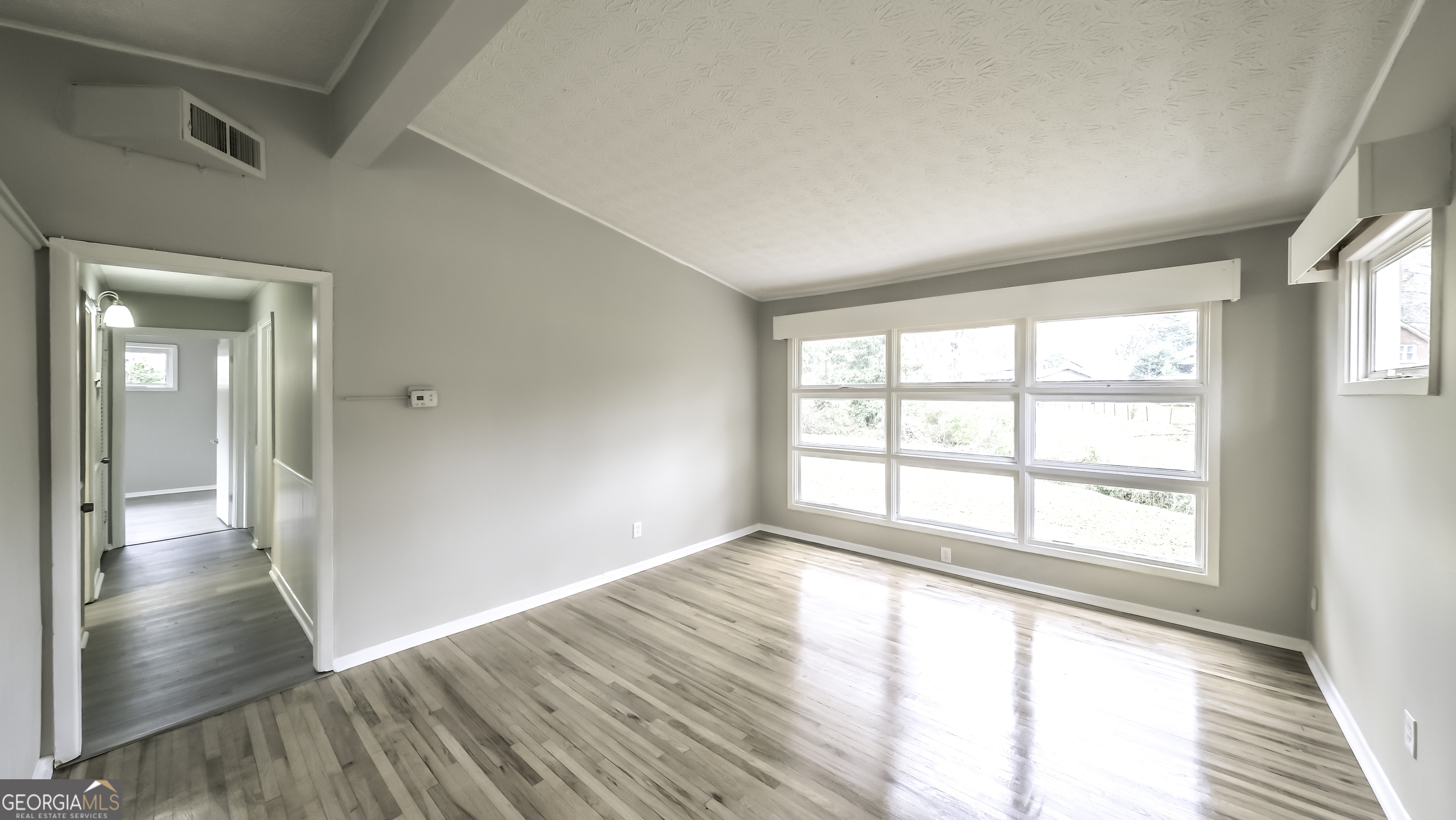 208 Richards Street Carrollton, GA 30117 - Photo 23 of 42 a view of an empty room with wooden floor and a window