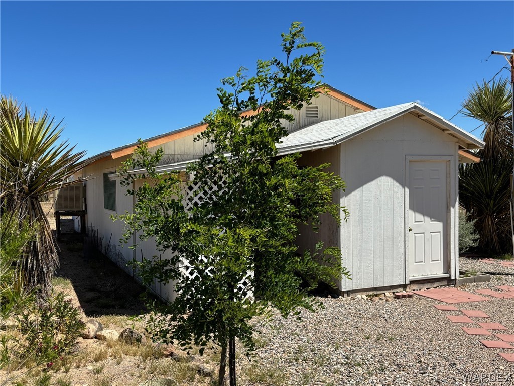 3565 Ehrenberg Road Golden Valley, AZ 86413 - Photo 21 of 63 a front view of a house with a yard and covered with trees