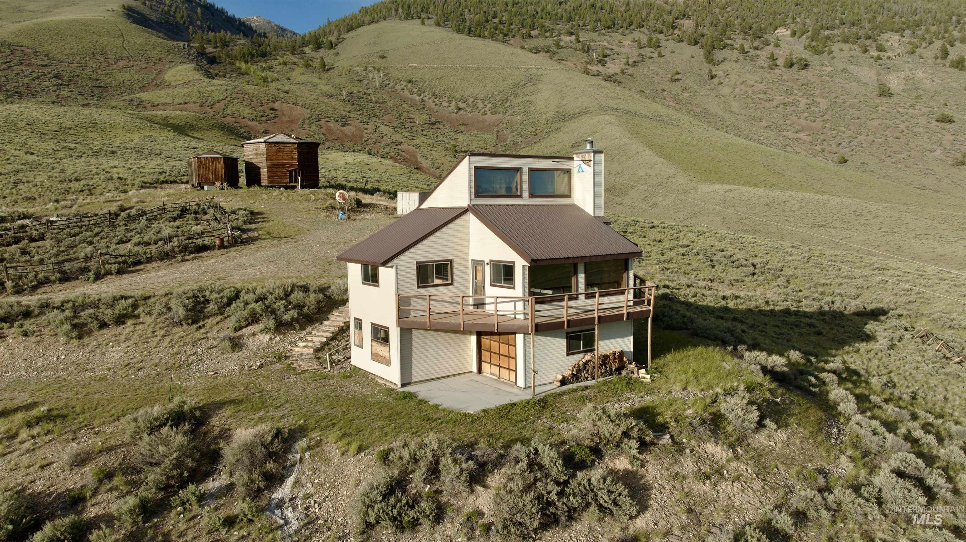 2040 Pahsimeroi River Road May, ID 83253 - Photo 2 of 29 Contemporary-style home featuring a brown metal roof, light-colored siding, and a spacious wooden deck