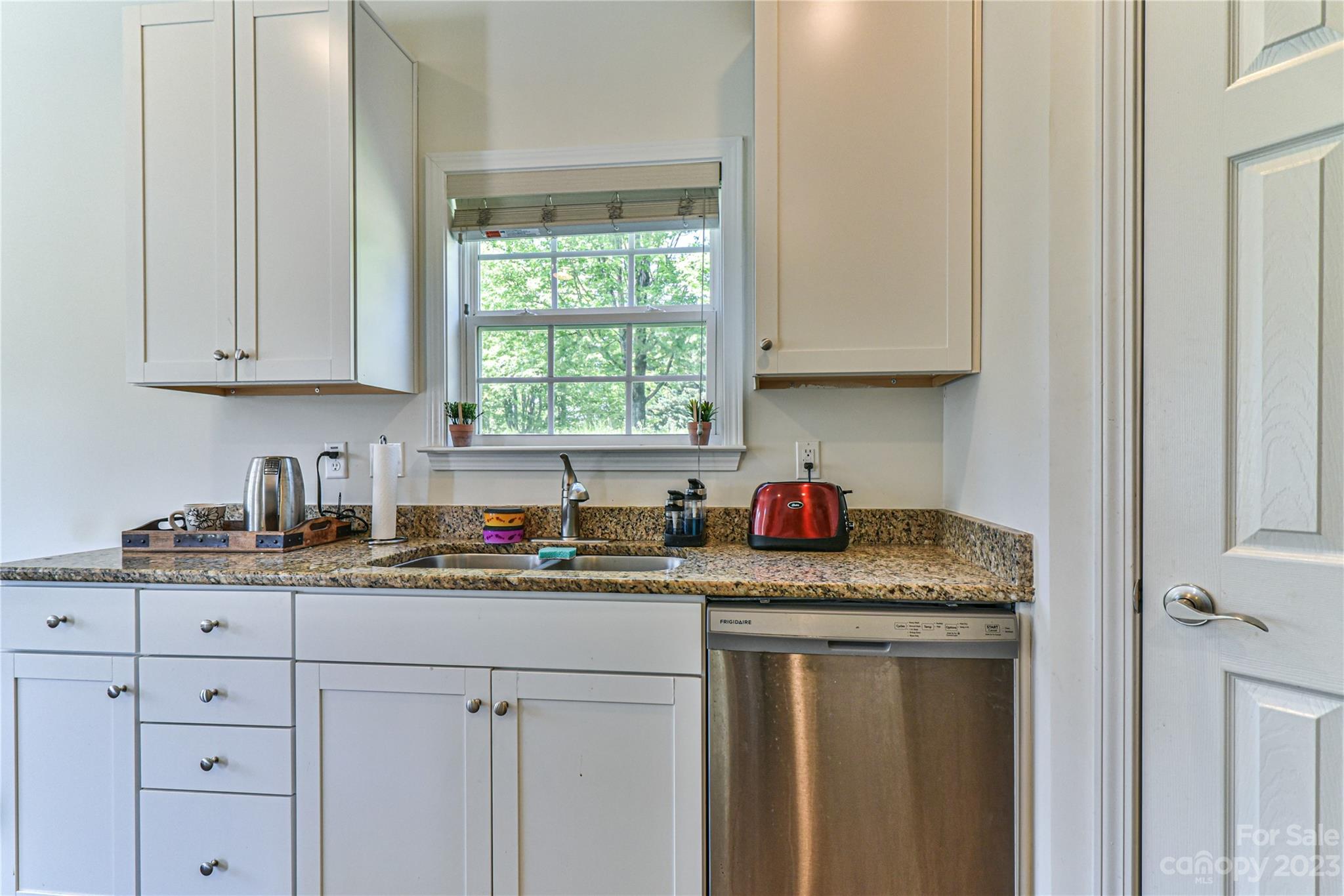 18 Yadkin Road Fletcher, NC 28732 - Photo 5 of 25 a kitchen with granite countertop a sink a stove and cabinets
