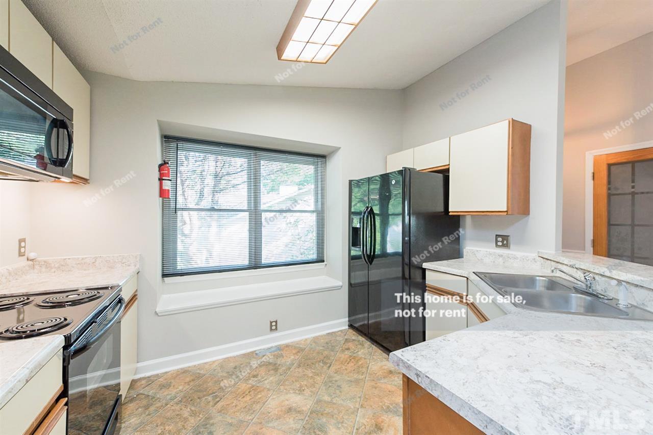 2412 Calvert Drive Raleigh, NC 27610 - Photo 2 of 19 a kitchen with a stove a sink and a refrigerator