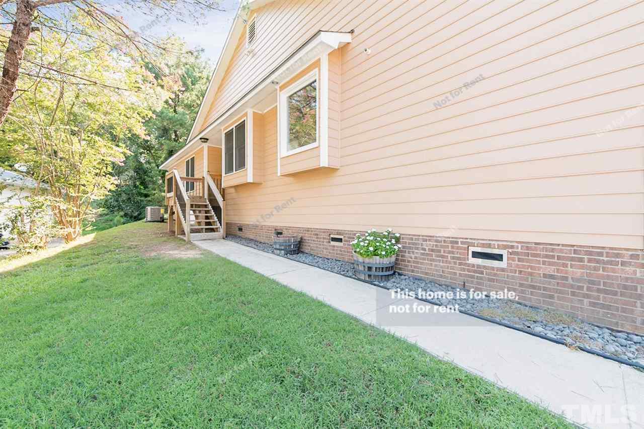 2412 Calvert Drive Raleigh, NC 27610 - Photo 19 of 19 a view of a backyard with chairs potted plants and wooden fence